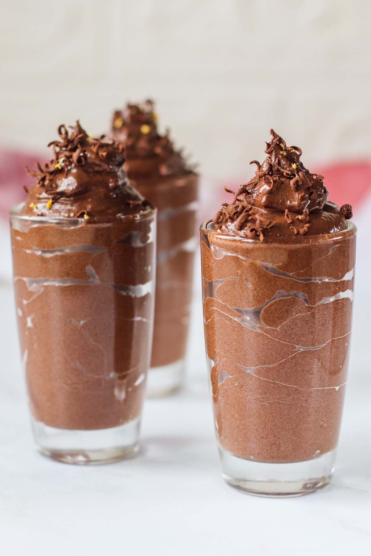 Chocolate mousse in glasses topped with shaved chocolate.